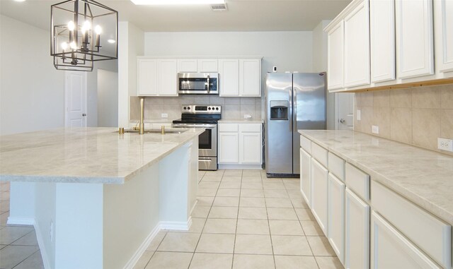 kitchen featuring light tile patterned floors, light stone countertops, visible vents, and stainless steel appliances