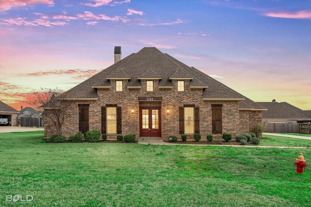 french country inspired facade featuring french doors, brick siding, and a shingled roof