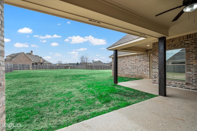 view of yard with a fenced backyard, a ceiling fan, and a patio area