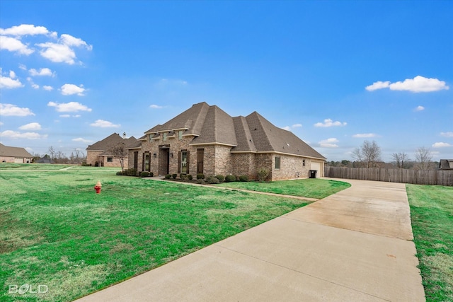 view of front of house with a garage, a front lawn, brick siding, and driveway