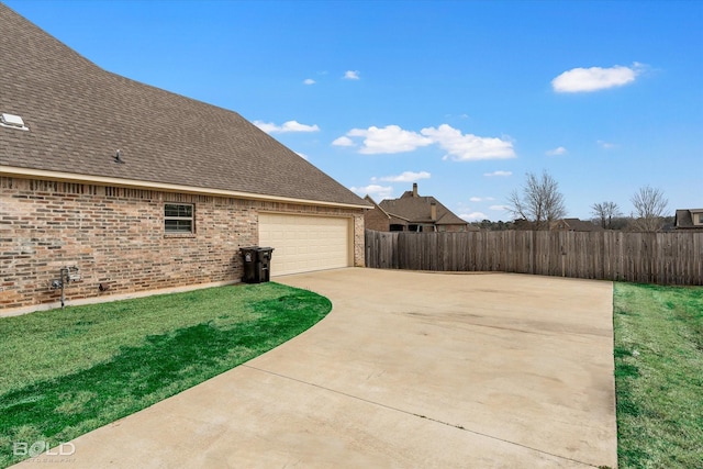 view of home's exterior featuring a yard, brick siding, a shingled roof, and fence