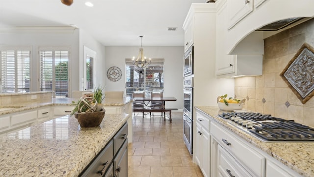 kitchen with visible vents, appliances with stainless steel finishes, white cabinets, decorative backsplash, and a chandelier