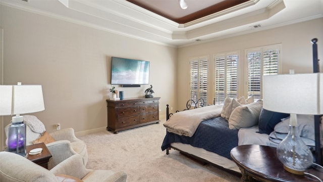 carpeted bedroom with a raised ceiling, visible vents, baseboards, and ornamental molding