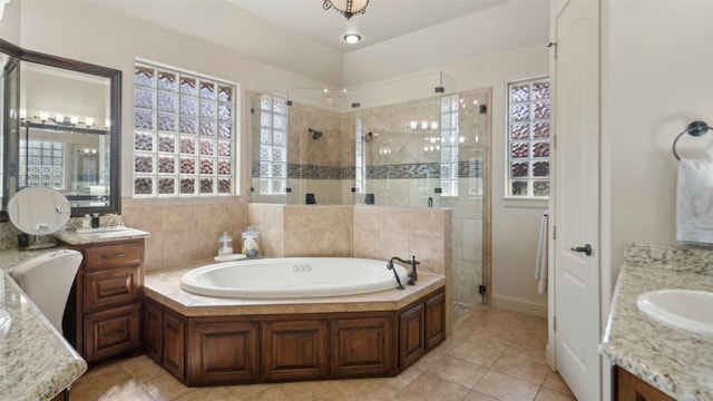 full bath featuring a shower stall, two vanities, a bath, and a sink