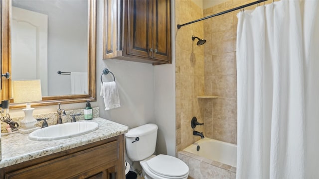 bathroom with vanity, toilet, and tiled shower / bath