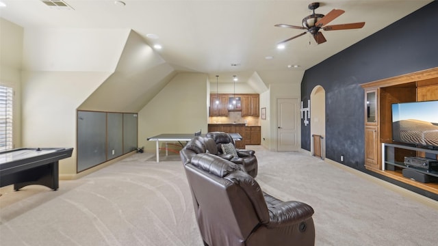 interior space featuring baseboards, lofted ceiling, arched walkways, ceiling fan, and light carpet