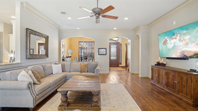 living area featuring wood finished floors, visible vents, recessed lighting, arched walkways, and ornamental molding