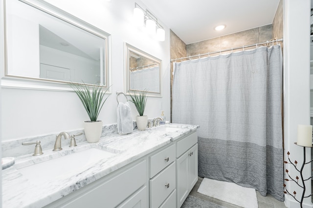 full bathroom with a sink, curtained shower, and double vanity