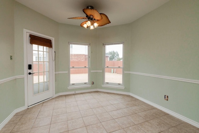 interior space with light tile patterned floors, ceiling fan, and baseboards