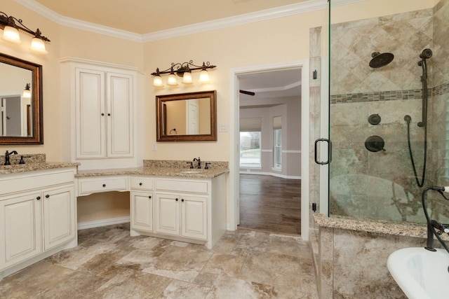 bathroom featuring a sink, a shower stall, double vanity, and ornamental molding