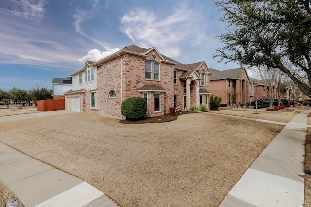 view of front of house featuring an attached garage, brick siding, and driveway