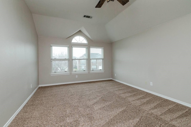 empty room featuring baseboards, visible vents, carpet floors, lofted ceiling, and ceiling fan