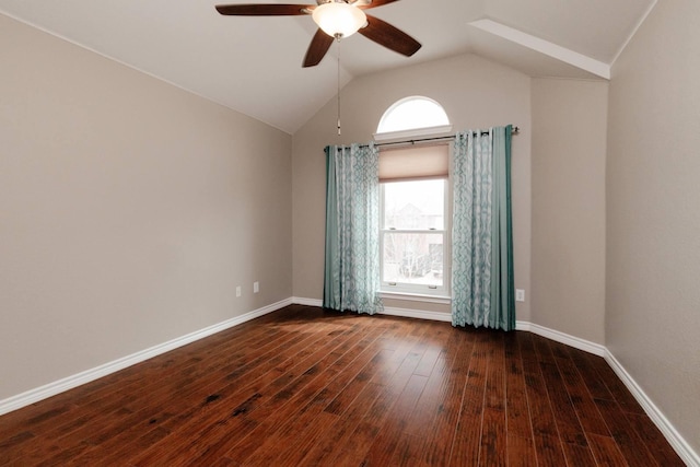 empty room with a wealth of natural light, vaulted ceiling, baseboards, and dark wood-style flooring