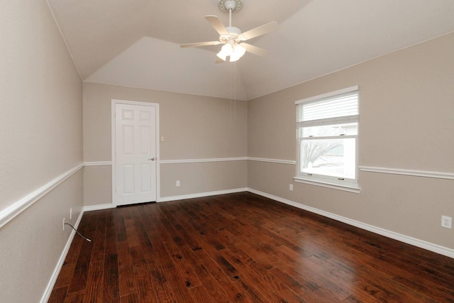 empty room with vaulted ceiling, a ceiling fan, baseboards, and dark wood-style flooring