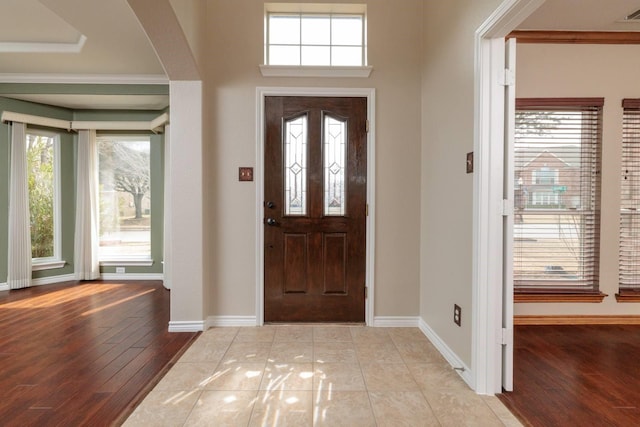 entryway with arched walkways, visible vents, baseboards, and wood finished floors