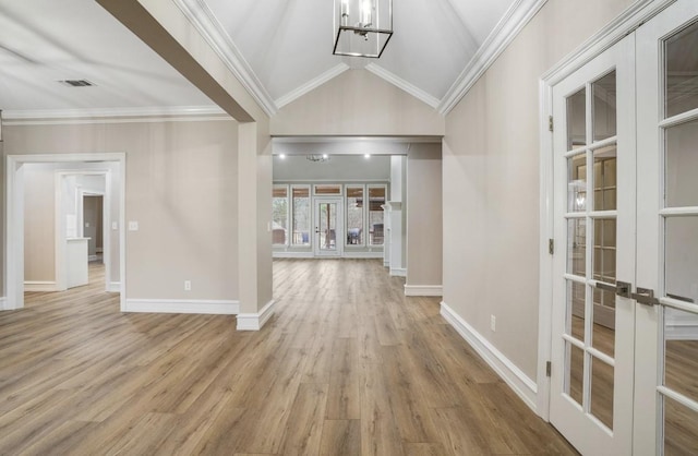 entryway with crown molding, wood finished floors, french doors, and vaulted ceiling