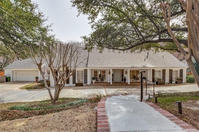 view of front facade featuring french doors, a garage, and driveway