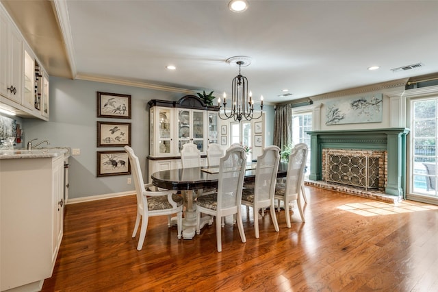 1905 Indian Creek Dr, Westover Hills, TX 76107 - dining room with crown molding, healthy amount of natural light, wood finished floors, a chandelier, and a brick fireplace