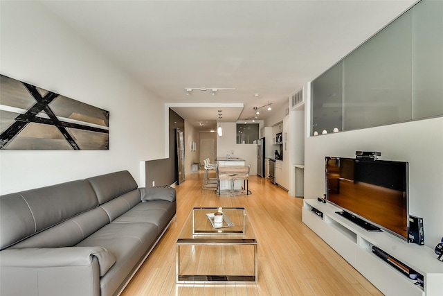 living room featuring visible vents, rail lighting, and light wood finished floors