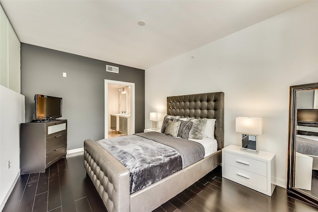 bedroom featuring baseboards, visible vents, dark wood-style flooring, and connected bathroom