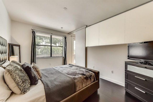 bedroom featuring baseboards and dark wood finished floors