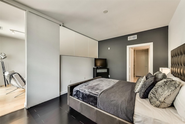 bedroom with visible vents and dark wood-style flooring