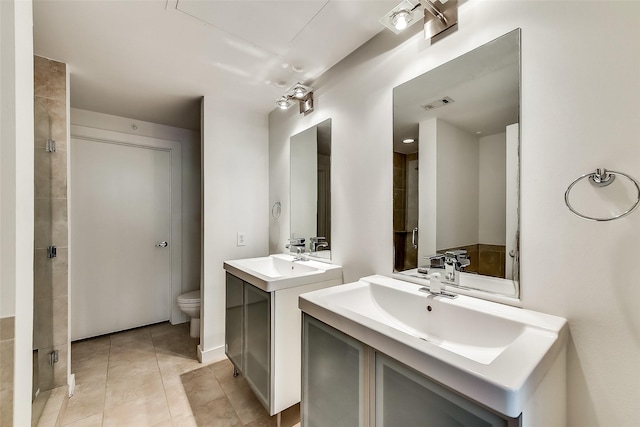 full bathroom with visible vents, toilet, two vanities, a sink, and tile patterned flooring