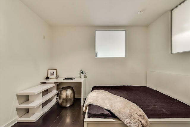 bedroom with baseboards and dark wood finished floors