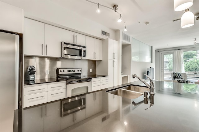 kitchen with a sink, dark countertops, visible vents, and stainless steel appliances