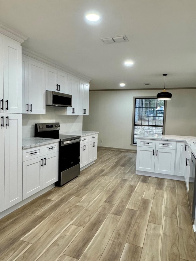 kitchen featuring stainless steel appliances, light wood-style flooring, crown molding, and white cabinetry