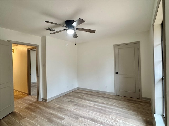 unfurnished room with ceiling fan, visible vents, baseboards, and light wood-style flooring