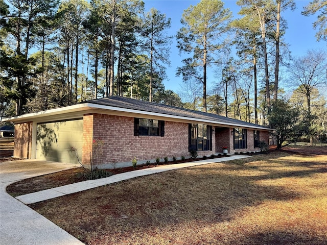 view of front facade featuring a front lawn, an attached garage, brick siding, and driveway