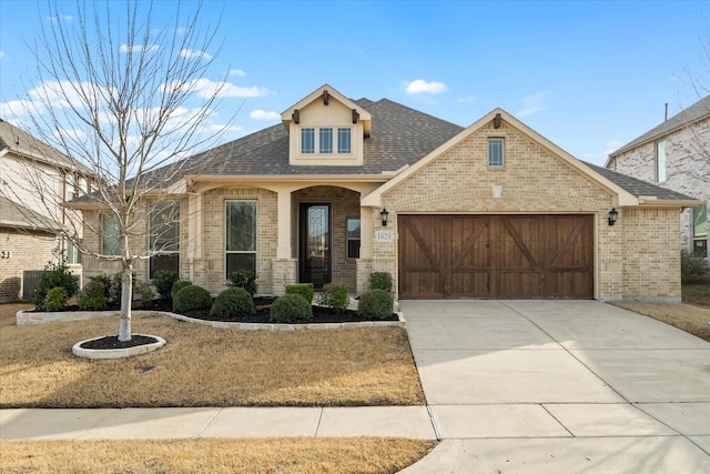 view of front of house featuring concrete driveway, a garage, brick siding, and roof with shingles