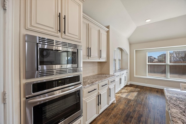 1621 Castleford Dr, Forney, TX 75126 - kitchen featuring stainless steel appliances, vaulted ceiling, dark wood-type flooring, light stone countertops, and tasteful backsplash