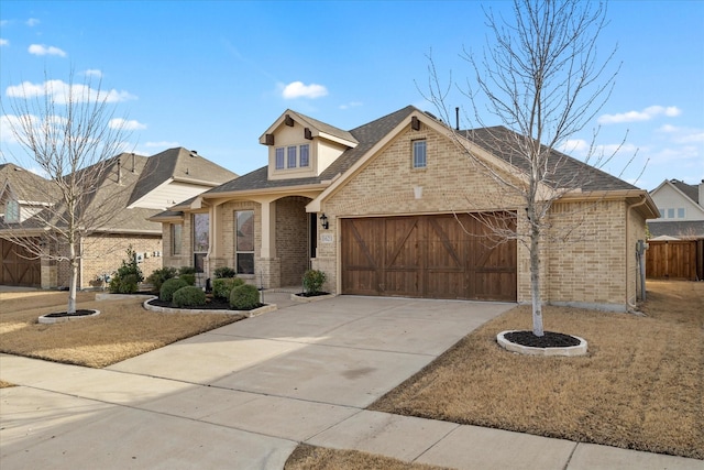 view of front facade featuring brick siding, concrete driveway, an attached garage, and fence