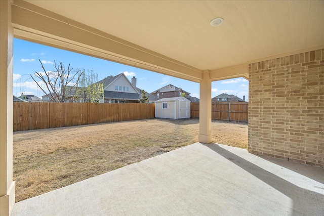 view of patio featuring an outdoor structure, a storage unit, and a fenced backyard