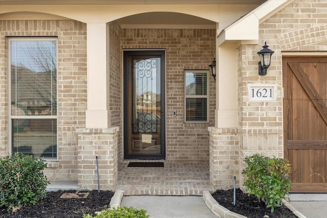 doorway to property featuring brick siding