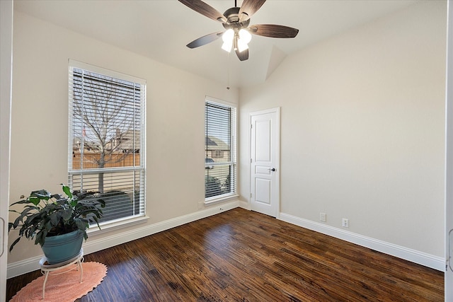 unfurnished room with dark wood finished floors, a ceiling fan, and baseboards