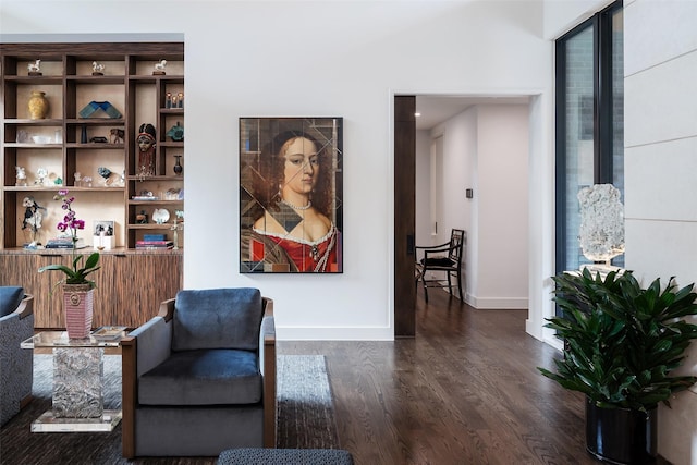 living area with baseboards and wood finished floors