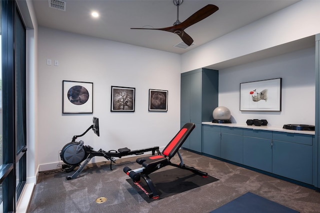 exercise room featuring a ceiling fan, visible vents, dark colored carpet, and baseboards