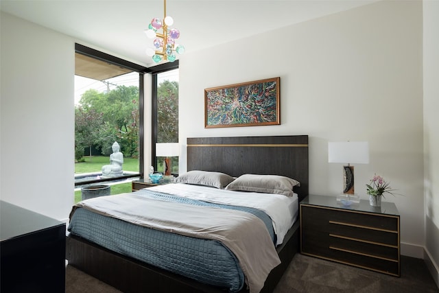 bedroom with dark carpet and expansive windows