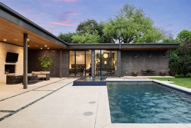 pool with an outdoor hangout area and a patio