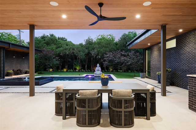 view of pool featuring a patio, a pool with connected hot tub, and a ceiling fan