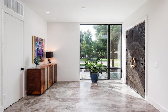 foyer entrance with a wealth of natural light, visible vents, baseboards, and recessed lighting