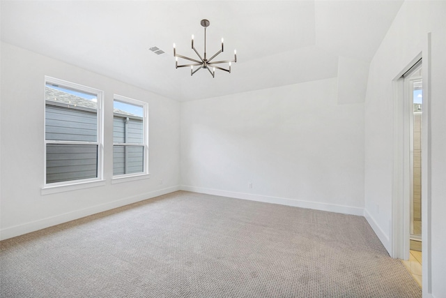 spare room with an inviting chandelier, baseboards, visible vents, and light carpet