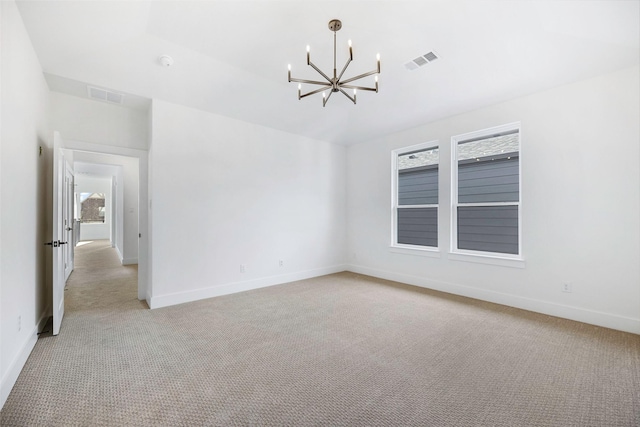 empty room featuring an inviting chandelier, light colored carpet, and visible vents