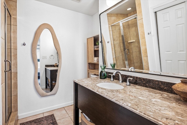 bathroom with tile patterned flooring, a stall shower, vanity, and baseboards