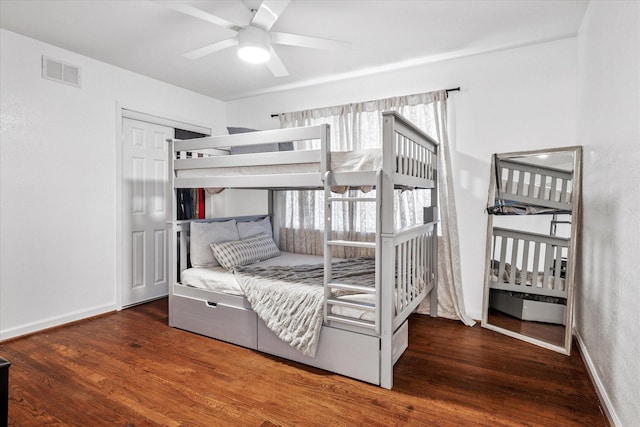 bedroom with wood finished floors, visible vents, and baseboards