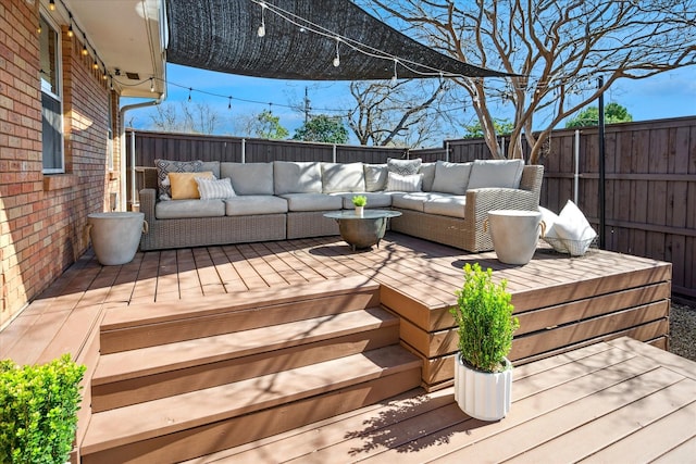 wooden deck with outdoor lounge area and a fenced backyard