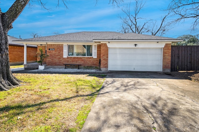 single story home featuring fence, concrete driveway, a front yard, a garage, and brick siding